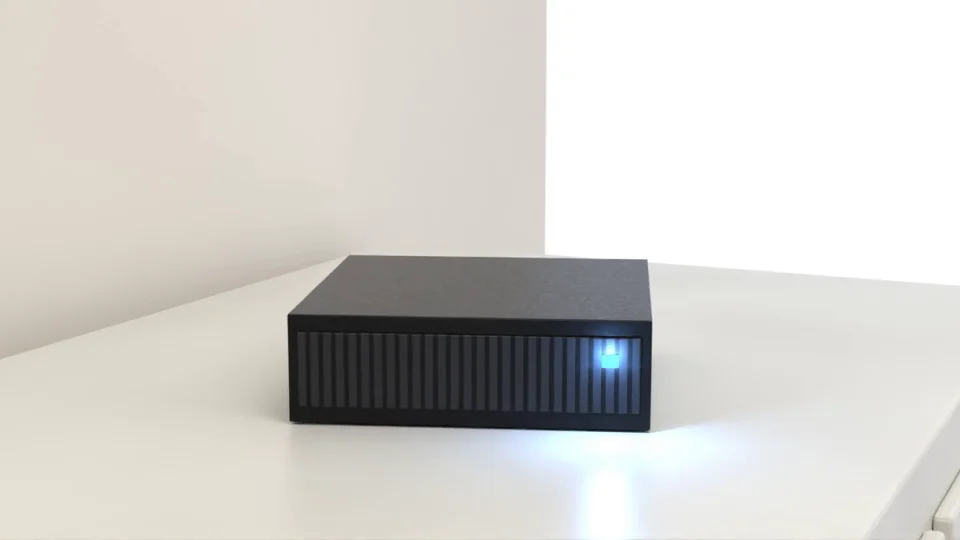 Kleiner schwarzer Rechner mit blauem Licht auf einem Tisch