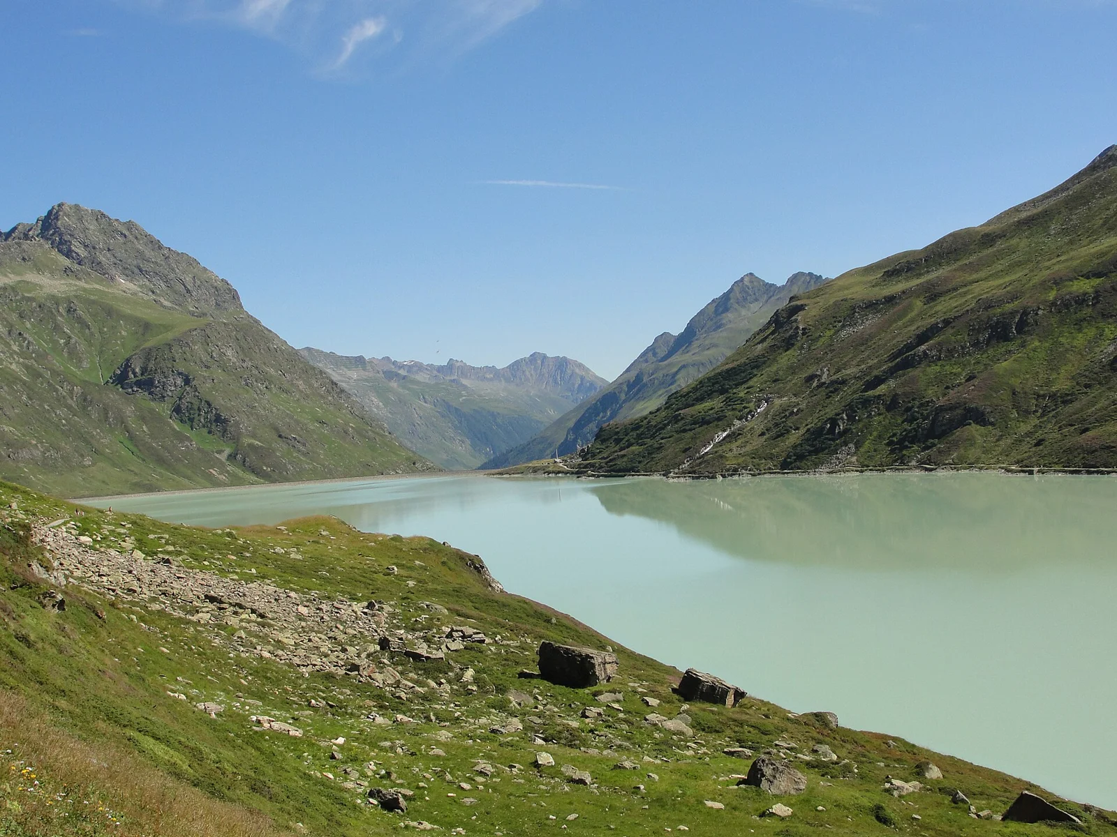 Bild 2: Türkiser Stausee zwischen grünen Berghängen